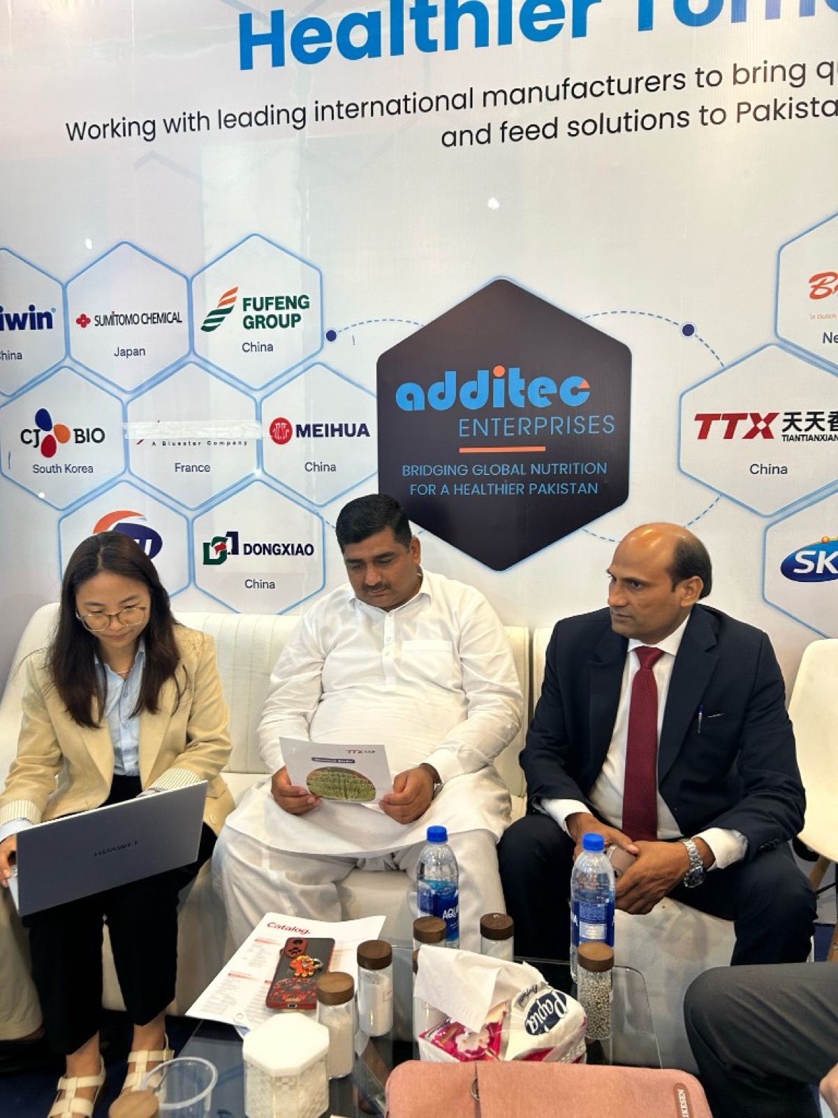 Additec team reviewing product information with a visitor at IPEX EXPO 2026