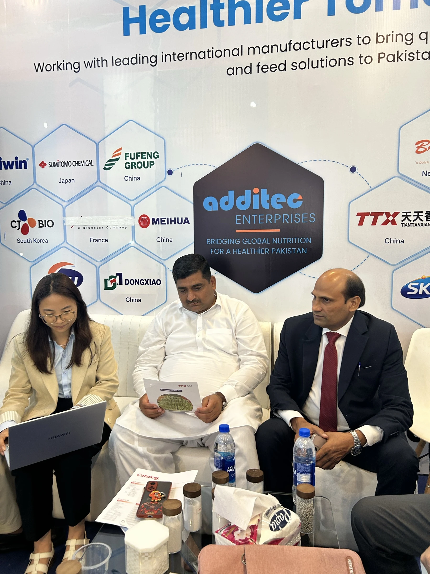 Brochure review during a booth meeting at Additec Enterprises, IPEX EXPO 2026