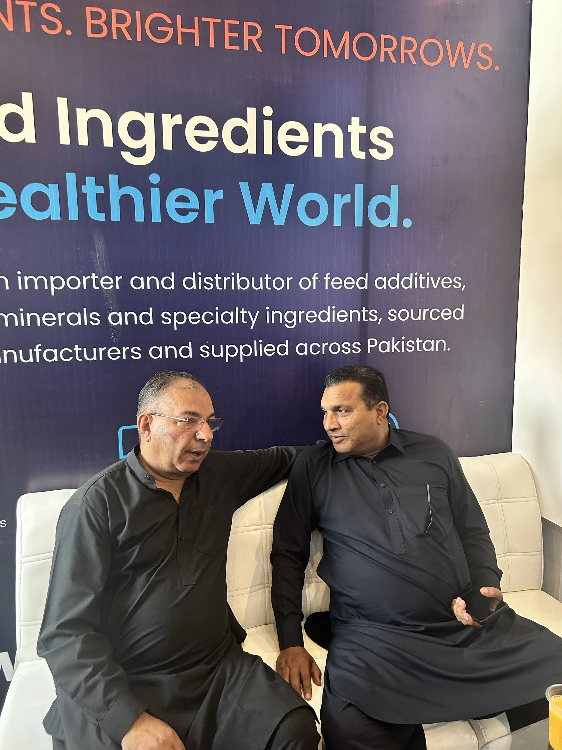 Two visitors in discussion at the Additec Enterprises exhibition stand