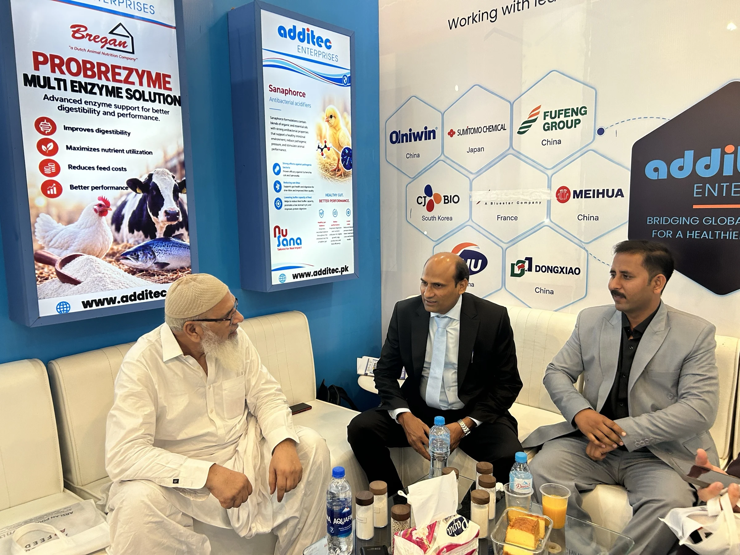 Three-person discussion with feed samples at the Additec booth on IPEX EXPO 2026 Day 02