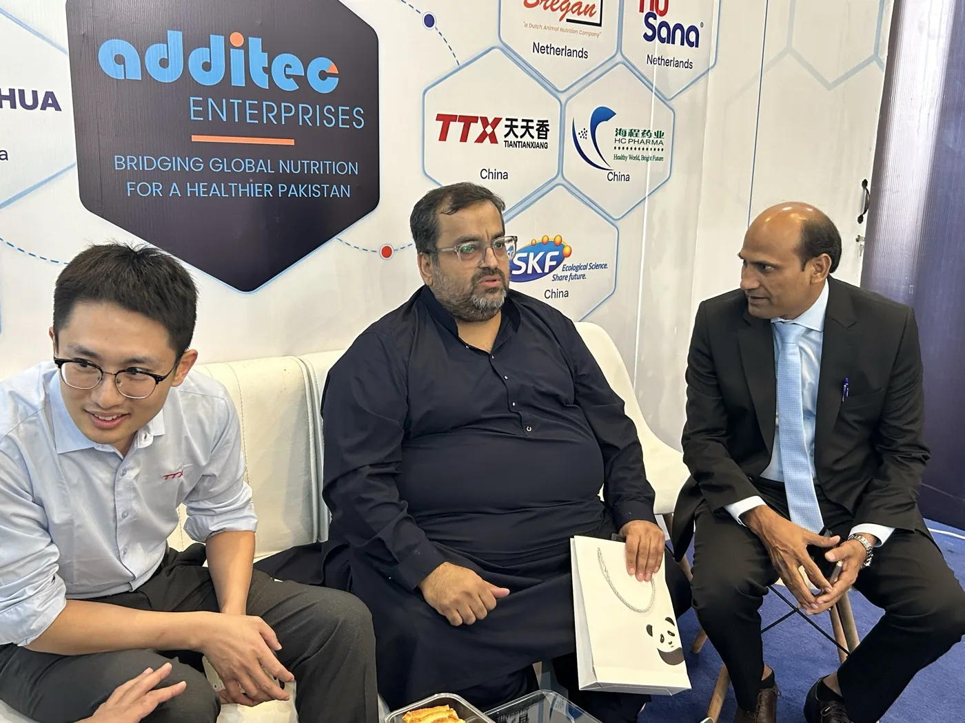 Conversation in front of Additec global partner logos at IPEX EXPO 2026