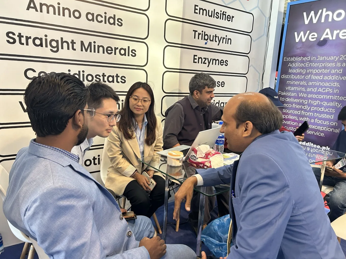 Visitors discussing feed ingredient categories at the Additec Enterprises IPEX stall